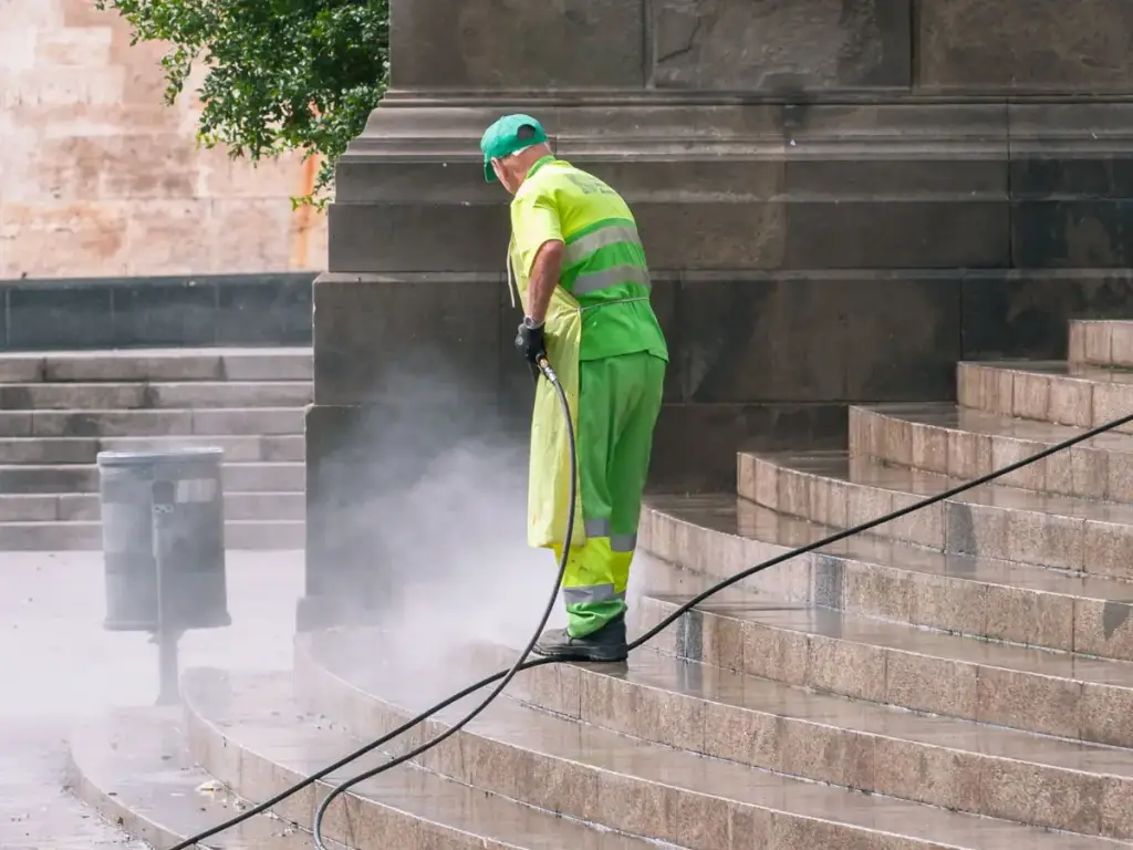 Worker pressure washing outdoor stone steps