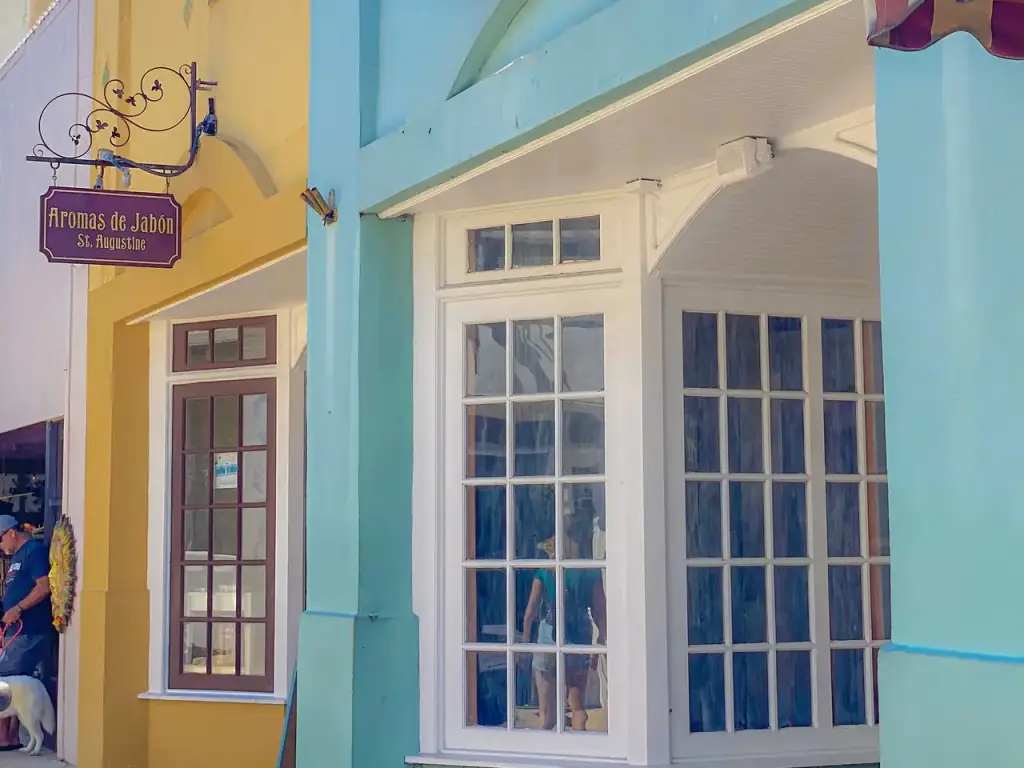 Painted storefronts and shop signs along a sidewalk