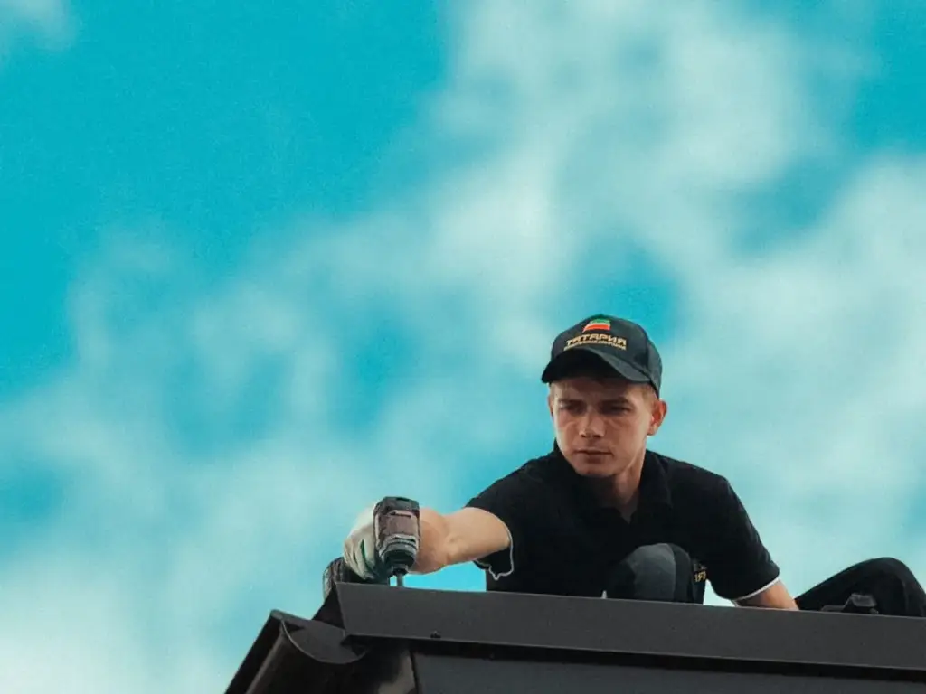 Worker at the edge of a dark house roof